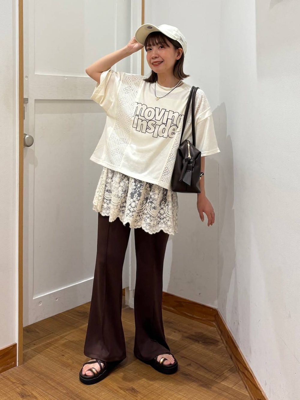 ブラウン系のボストンバッグ、ブラウン系のサンダル、ベージュ系のTシャツ/カットソーを着用したレディースの夏コーディネートの1枚目の写真