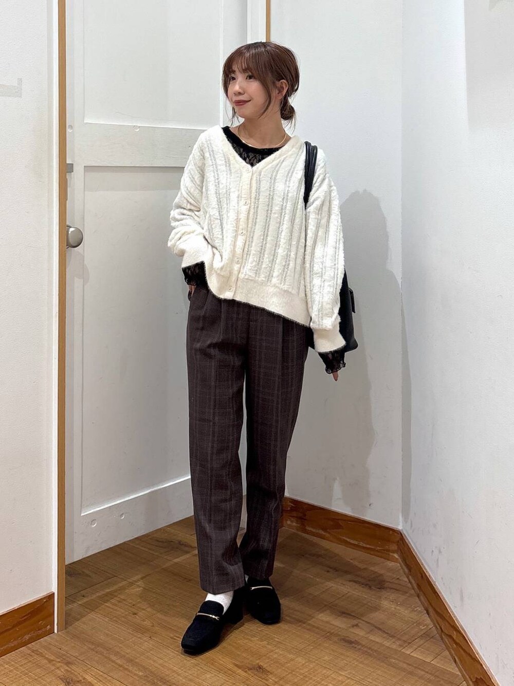 ブラック系のローファー、ブラック系のトートバッグ、ホワイト系のカーディガン/ボレロを着用したレディースの秋コーディネートの1枚目の写真