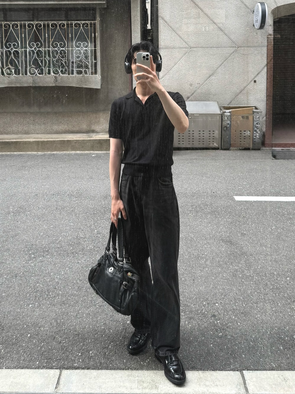 グレー系のデニムパンツ、ブラック系のバッグ、ブラック系のローファーを着用したメンズの夏コーディネートの1枚目の写真