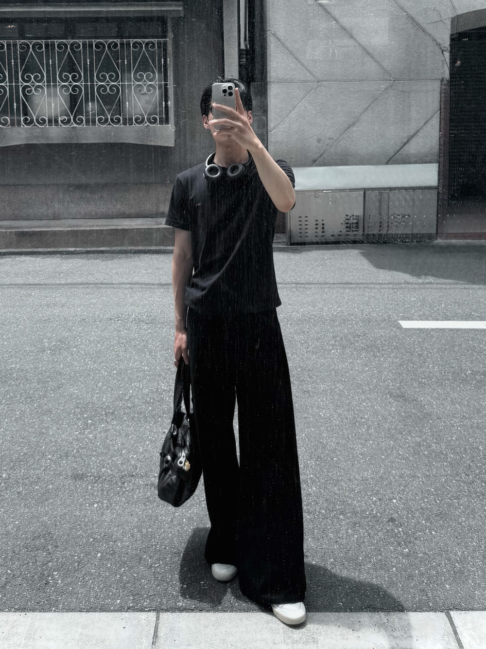 ブラック系のデニムパンツ、ホワイト系のスニーカー、ブラック系のバッグを着用したメンズの夏コーディネートの1枚目の写真