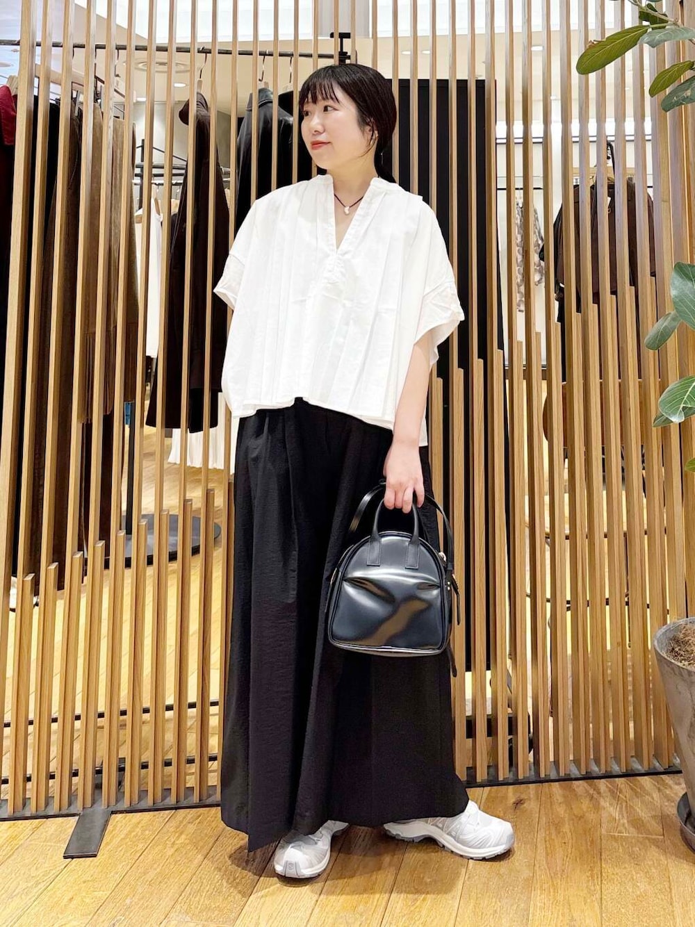 ブラック系のショルダーバッグ、ブラック系のその他パンツ、ホワイト系のシャツ/ブラウスを着用したレディースの夏コーディネートの1枚目の写真