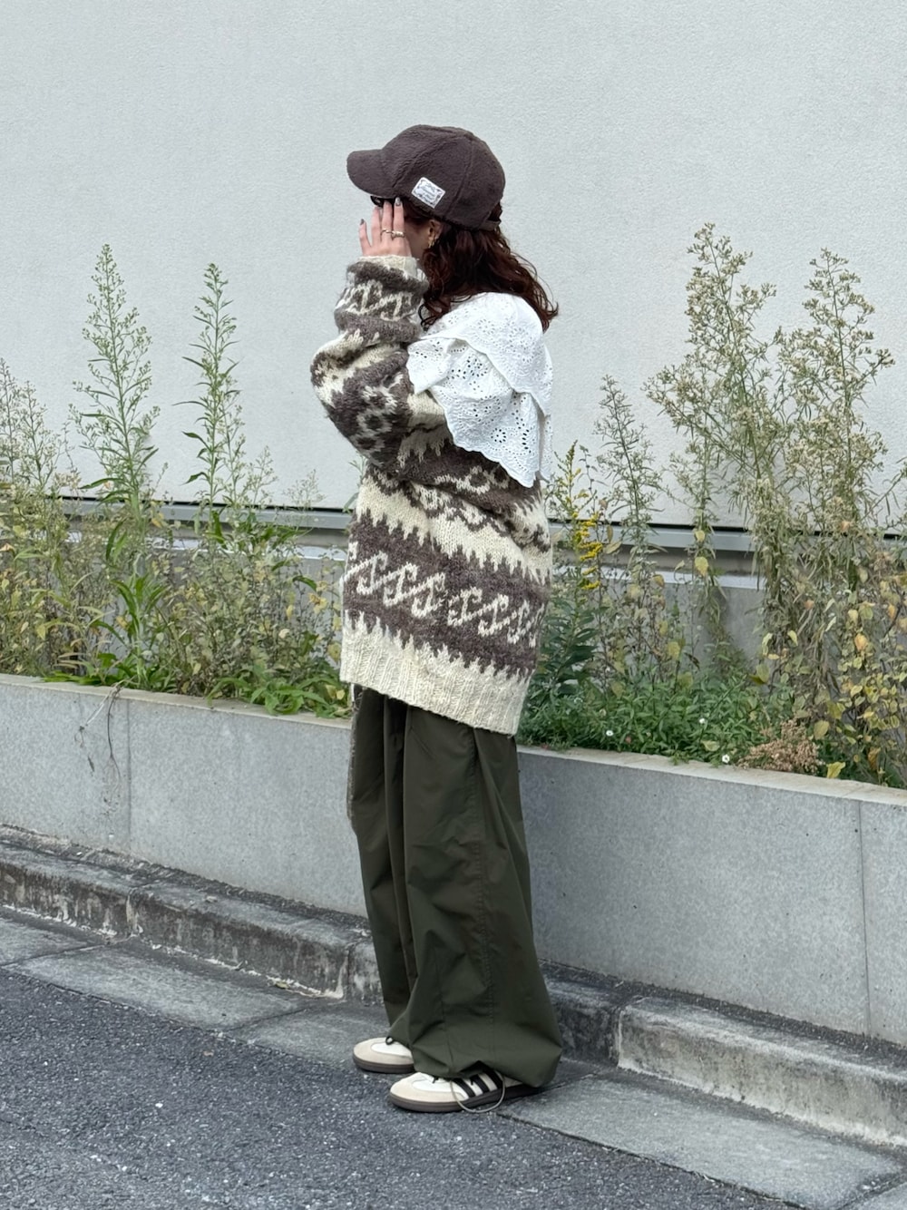 ホワイト系のカーディガン/ボレロ、グリーン系のカーゴパンツ、ベージュ系のスニーカーを着用したレディースの秋コーディネートの1枚目の写真