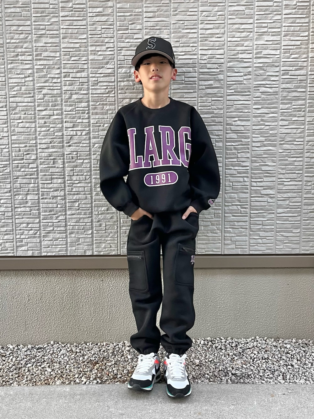 ブラック系のスウェット、ブラック系のスウェットパンツ、ホワイト系のスニーカーを着用したキッズの秋コーディネートの1枚目の写真