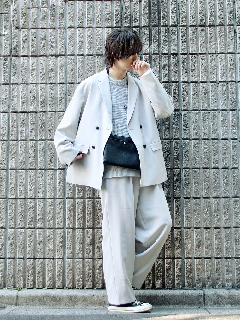 グレー系のテーラードジャケット、グレー系のベスト、ブラック系のショルダーバッグを着用したメンズの春コーディネートの1枚目の写真