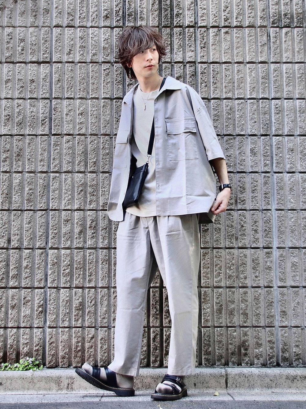 グレー系のセットアップ、ブラック系のショルダーバッグ、グレー系のTシャツ/カットソーを着用したメンズの春コーディネートの1枚目の写真