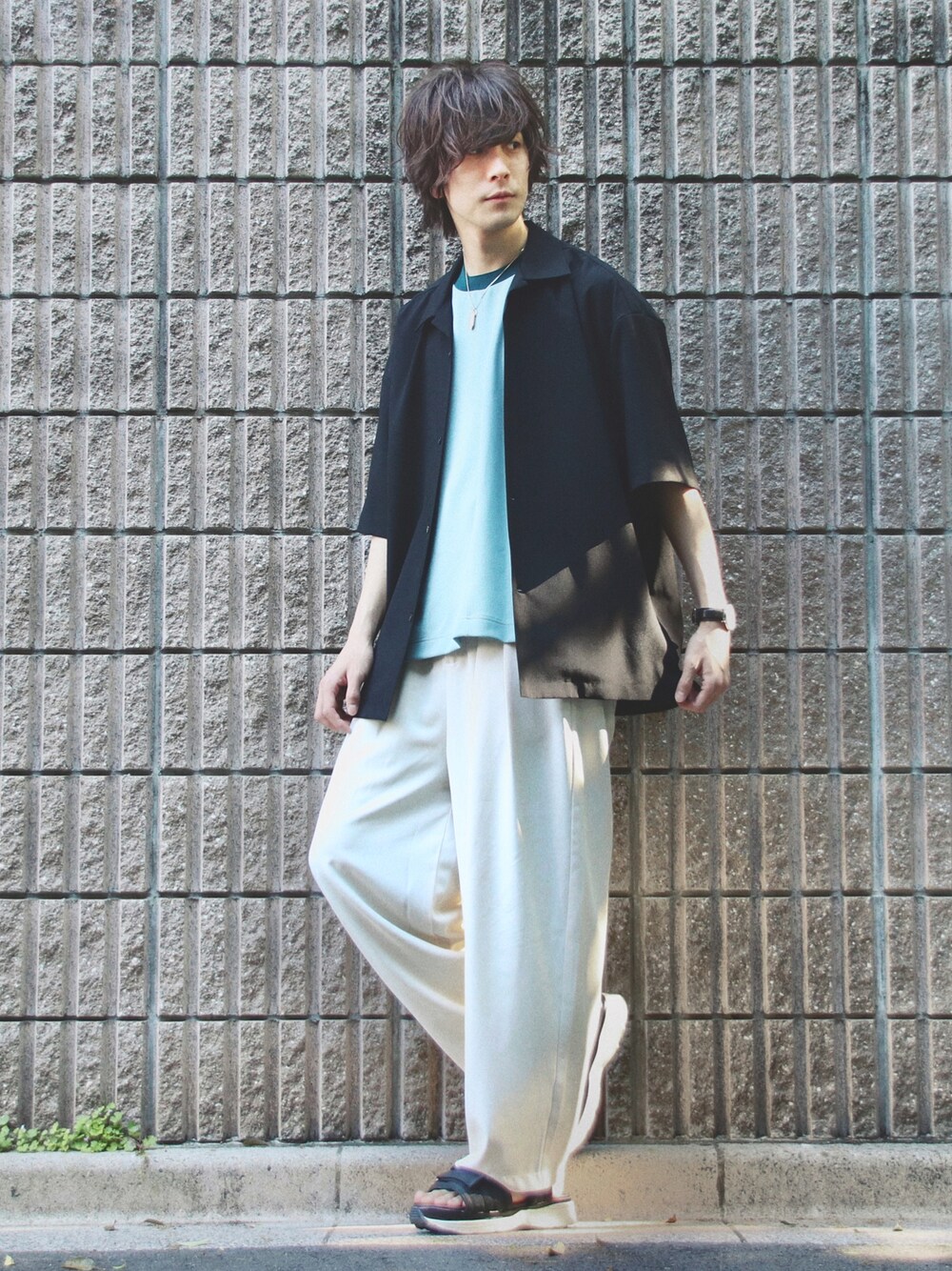 ブラック系のシャツ/ブラウス、グリーン系のTシャツ/カットソー、ベージュ系のスラックスを着用したメンズの春コーディネートの1枚目の写真