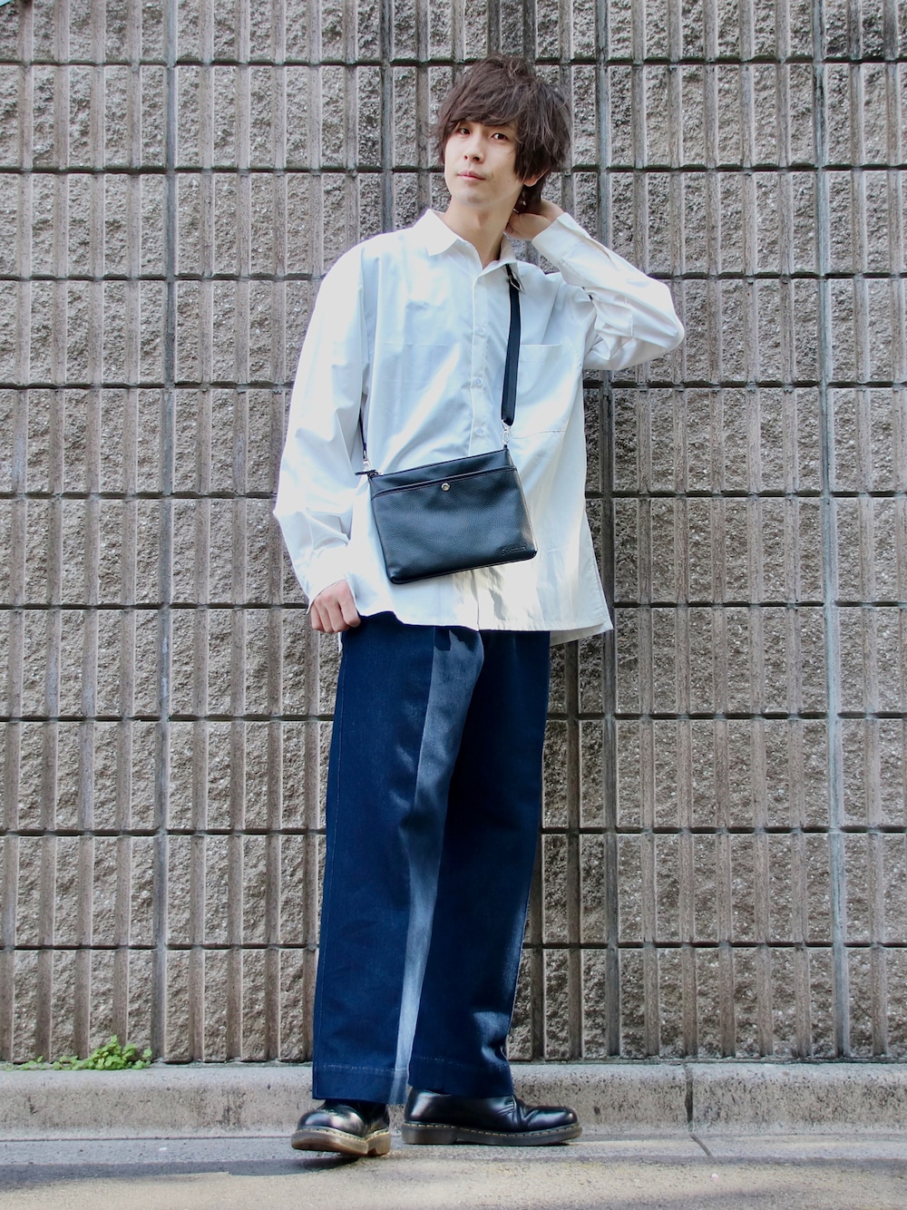 ブルー系のデニムパンツ、ブラック系のショルダーバッグ、ホワイト系のシャツ/ブラウスを着用したメンズの春コーディネートの1枚目の写真