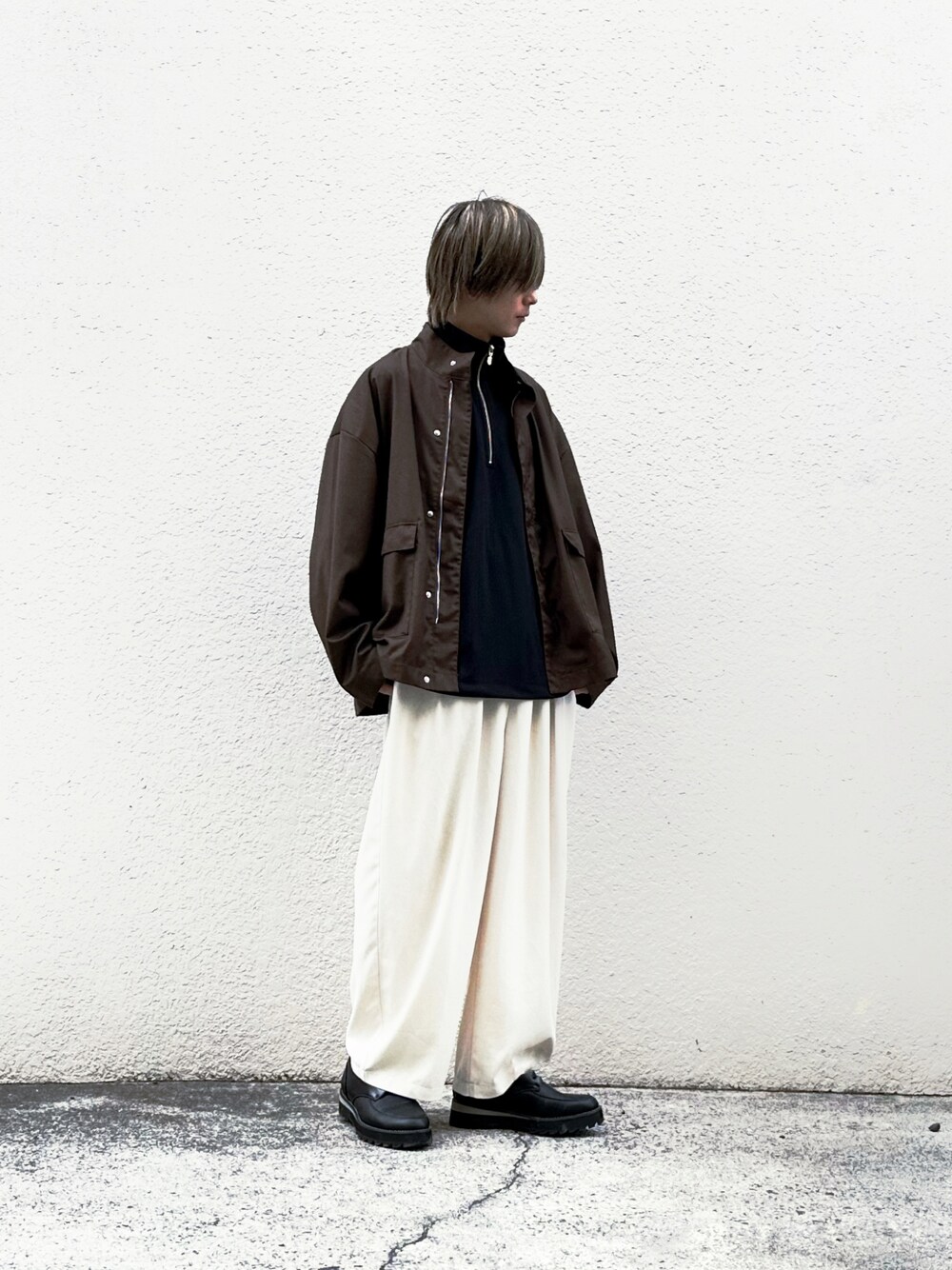 ブラウン系のブルゾン、ブラック系のTシャツ/カットソー、ベージュ系のスラックスを着用したメンズの夏コーディネートの1枚目の写真