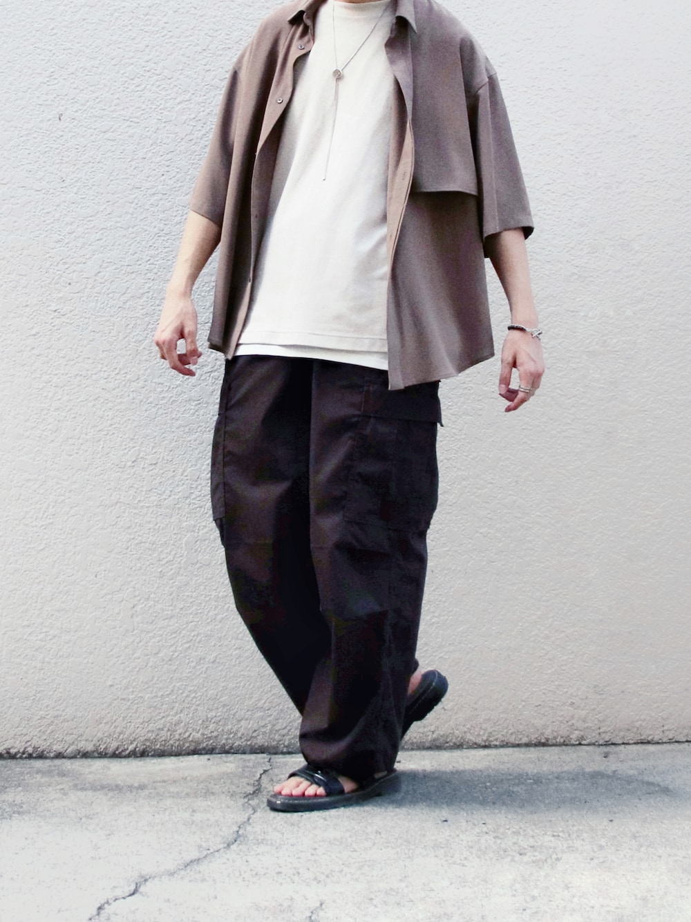 ベージュ系のシャツ/ブラウス、ブラウン系のカーゴパンツ、ブラック系のサンダルを着用したメンズの夏コーディネートの1枚目の写真