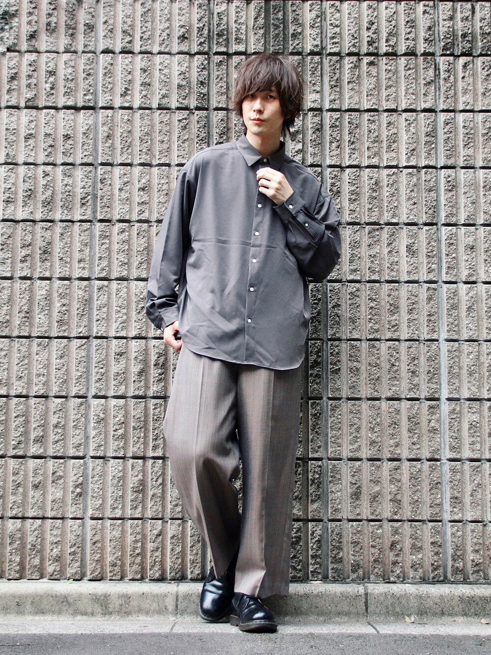 グレー系のシャツ/ブラウス、ベージュ系のスラックス、ブラック系のドレスシューズを着用したメンズの夏コーディネートの1枚目の写真