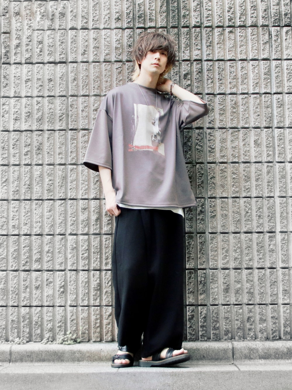 ブラウン系のTシャツ/カットソー、ブラック系のその他パンツ、ブラック系のサンダルを着用したメンズの春コーディネートの1枚目の写真