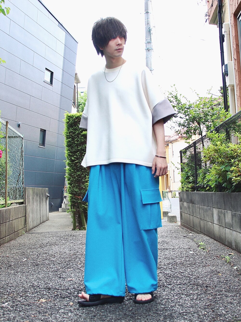 ブルー系のカーゴパンツ、ブラック系のサンダル、ホワイト系のTシャツ/カットソーを着用したメンズの夏コーディネートの1枚目の写真