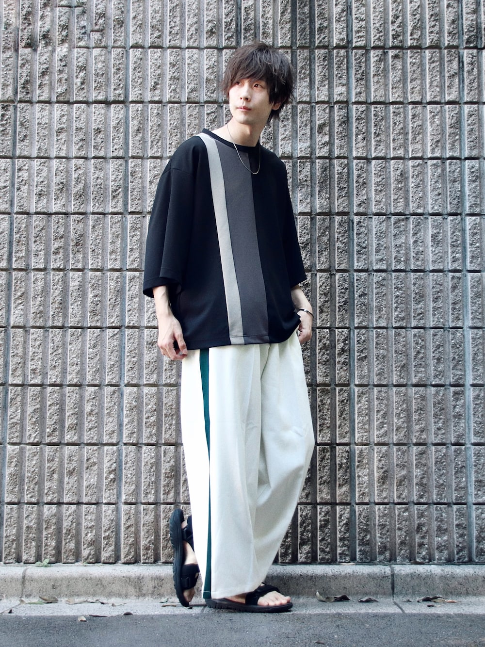 ブラック系のTシャツ/カットソー、ホワイト系のスラックス、ブラック系のサンダルを着用したメンズの夏コーディネートの1枚目の写真