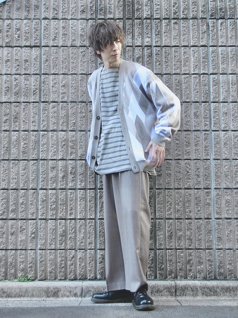 ベージュ系のスラックス、ブラック系のドレスシューズ、グレー系のTシャツ/カットソーを着用したメンズの春コーディネートの1枚目の写真
