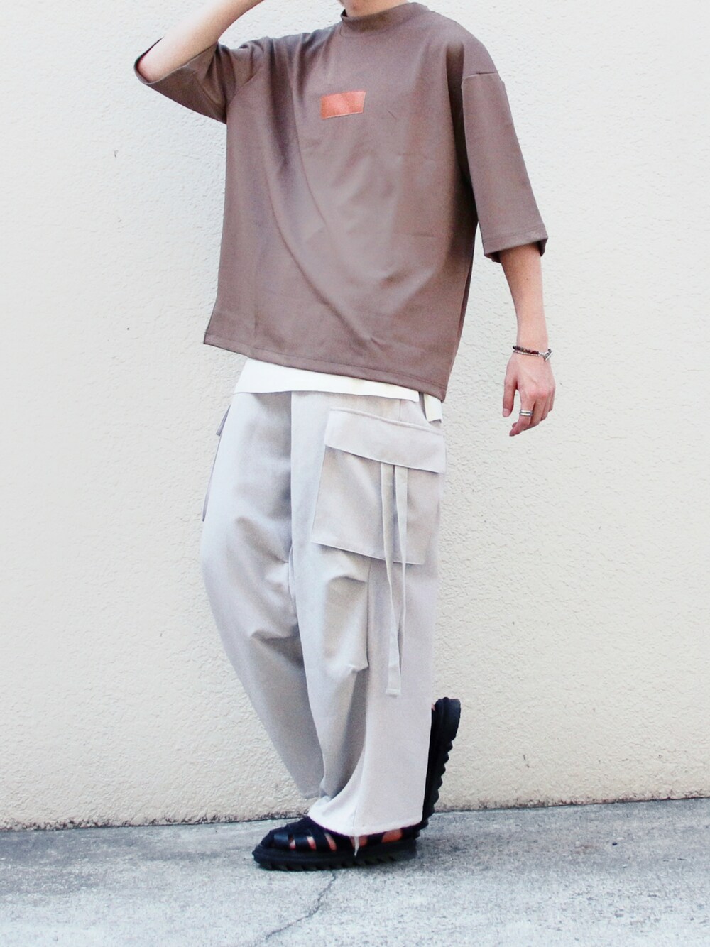 ブラウン系のTシャツ/カットソー、ホワイト系のタンクトップ、グレー系のカーゴパンツを着用したメンズの夏コーディネートの1枚目の写真