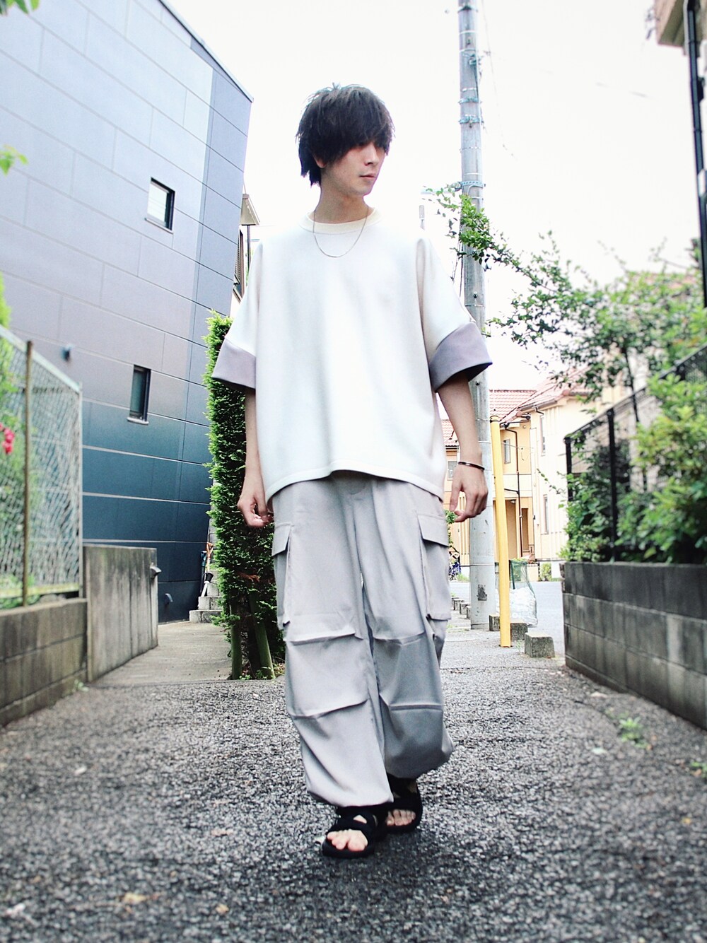 グレー系のカーゴパンツ、ホワイト系のTシャツ/カットソー、ブラック系のサンダルを着用したメンズの夏コーディネートの1枚目の写真