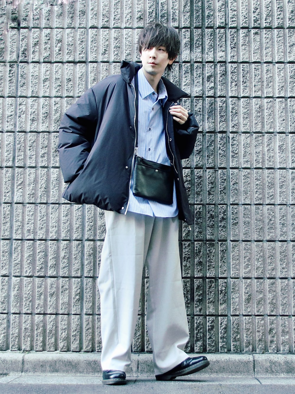 ブラック系のダウンジャケット/コート、ブルー系のシャツ/ブラウス、ブラック系のショルダーバッグを着用したメンズの冬コーディネートの1枚目の写真