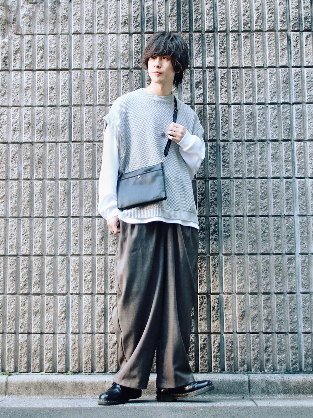 グレー系のベスト、ホワイト系のTシャツ/カットソー、グレー系のスラックスを着用したメンズの春コーディネートの1枚目の写真