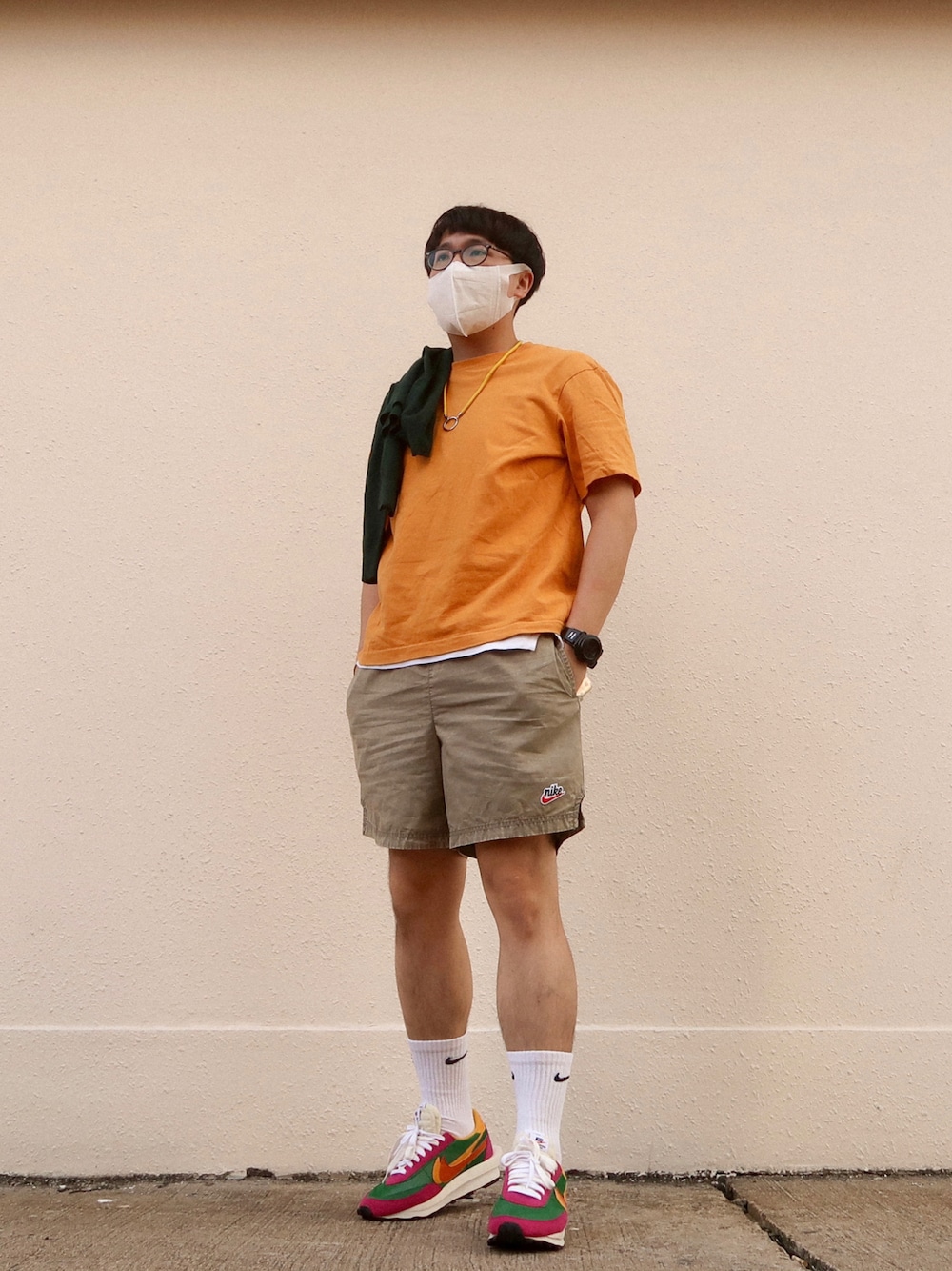 グリーン系のスニーカー、グリーン系のカーゴパンツ、オレンジ系のTシャツ/カットソーを着用したメンズの秋コーディネートの1枚目の写真