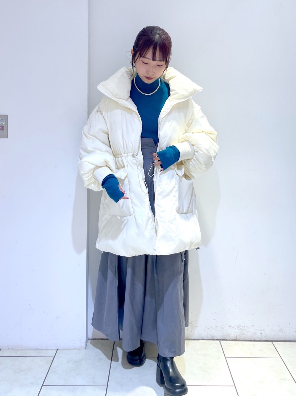 ブラック系のブーツ、グレー系のジャンパースカート、ホワイト系のジャケット/アウターを着用したレディースの秋コーディネートの1枚目の写真