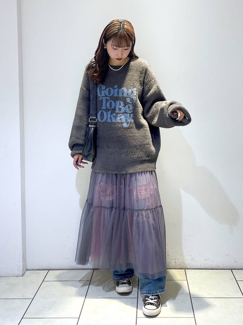 ブルー系のデニムパンツ、ブラック系のショルダーバッグ、グレー系のニット/セーターを着用したレディースの冬コーディネートの1枚目の写真