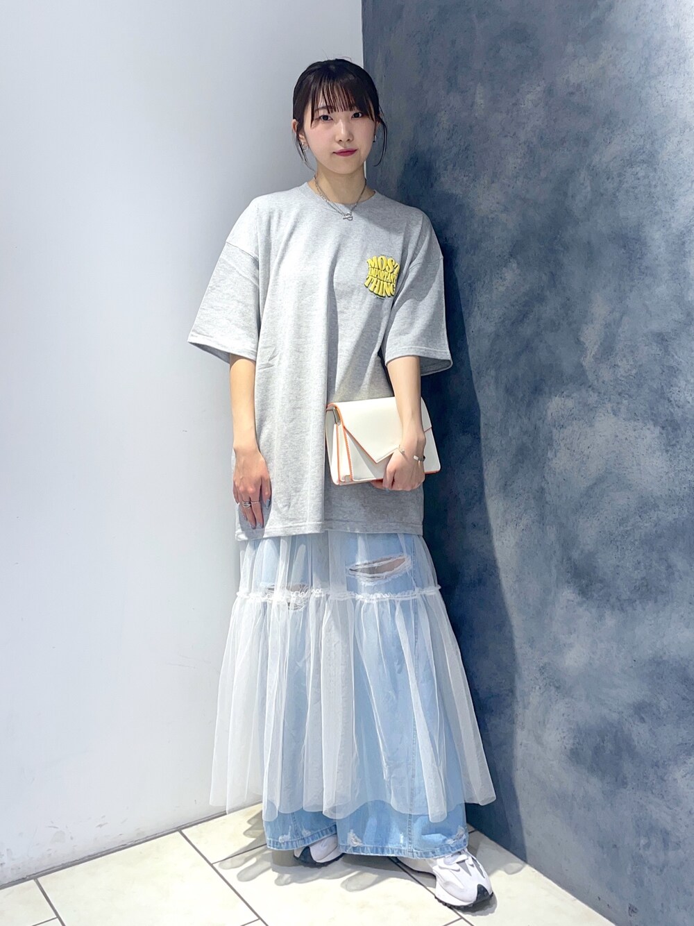 グレー系のTシャツ/カットソー、ホワイト系のワンピース、ブルー系のデニムパンツを着用したレディースの春コーディネートの1枚目の写真