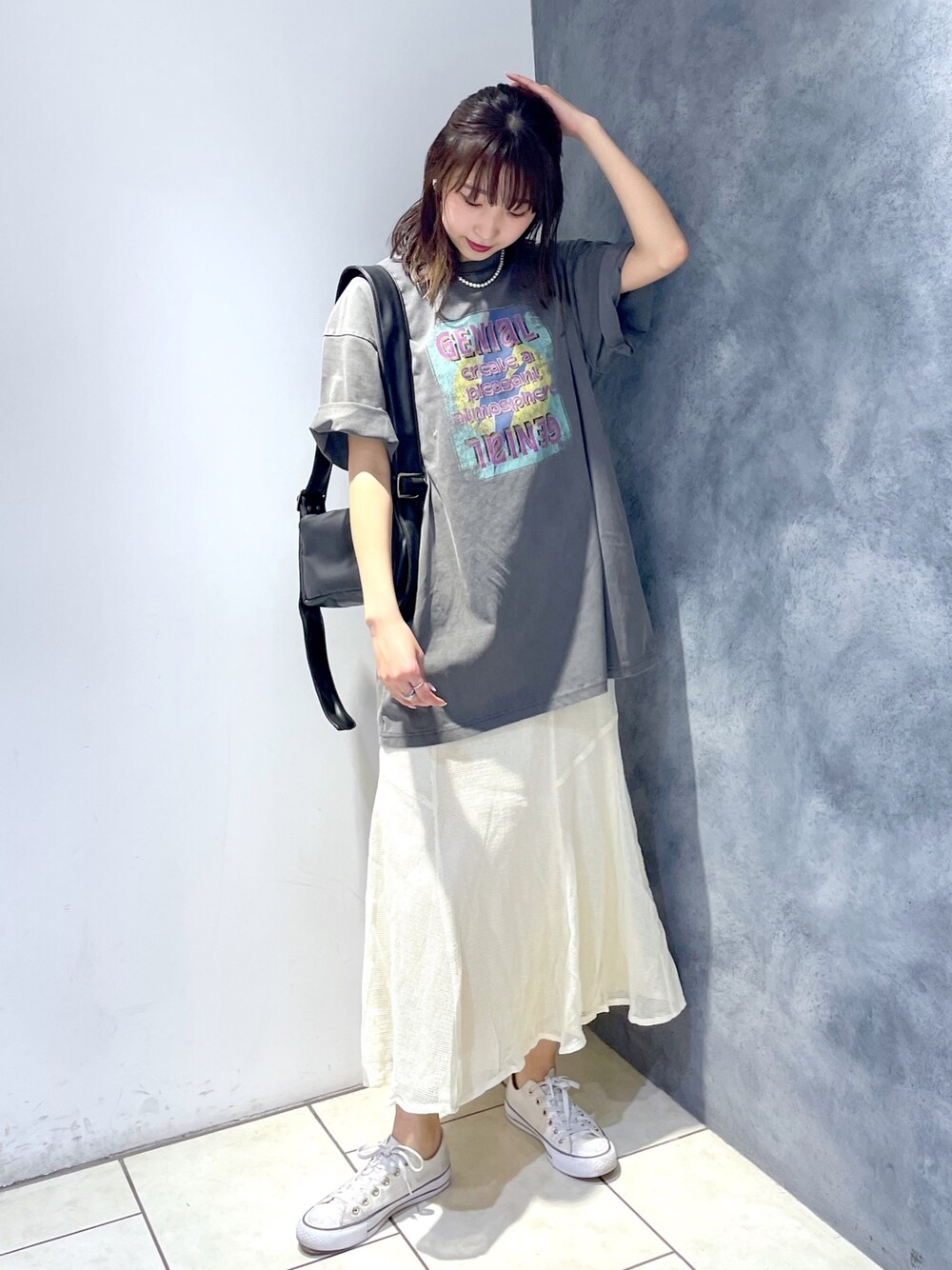 グレー系のTシャツ/カットソー、ホワイト系のスカート、ブラック系のバッグを着用したレディースの春コーディネートの1枚目の写真