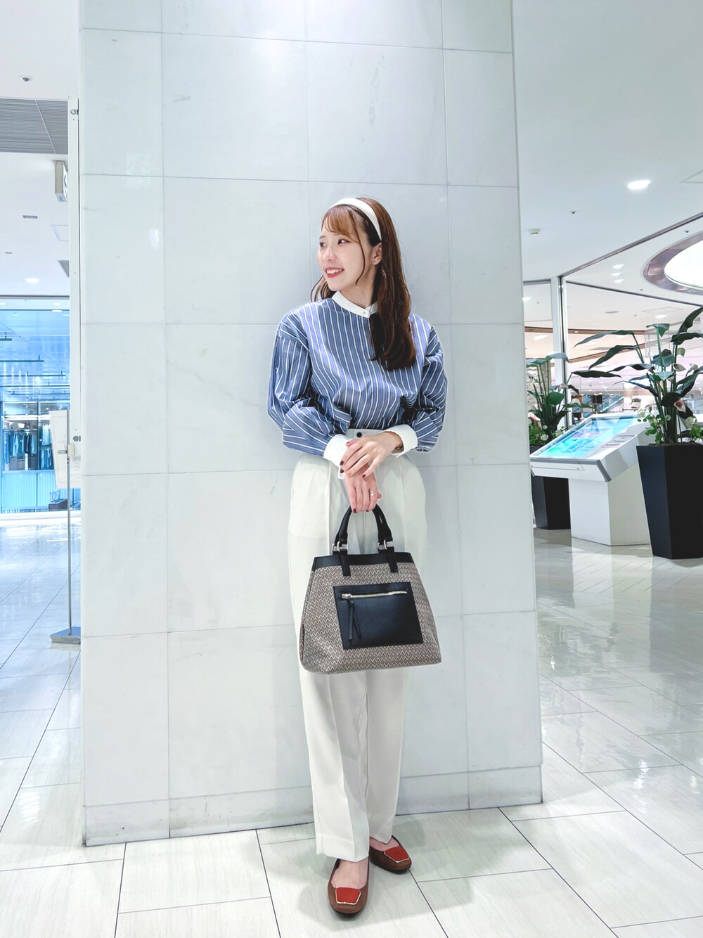 ブルー系のシャツ/ブラウス、ホワイト系のその他パンツ、ブラウン系のハンドバッグを着用したレディースの秋コーディネートの1枚目の写真