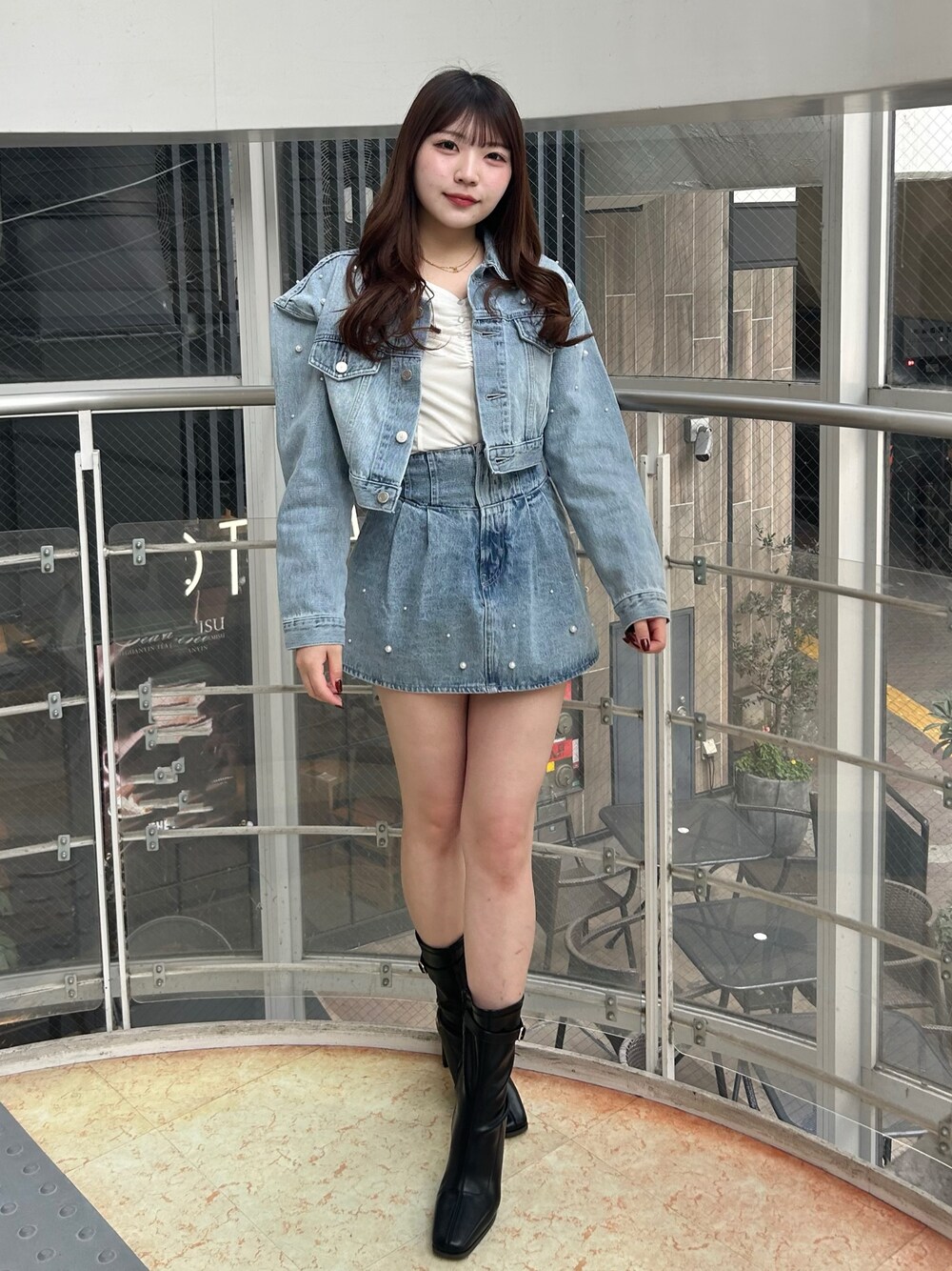 ブルー系のデニムジャケット、ブルー系のデニムパンツ、ブラック系のブーツを着用したレディースの冬コーディネートの1枚目の写真