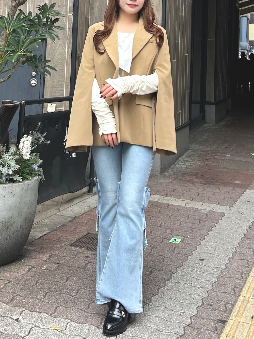 ブルー系のデニムパンツ、ブラウン系のパンプス、ベージュ系のテーラードジャケットを着用したレディースの春コーディネートの1枚目の写真