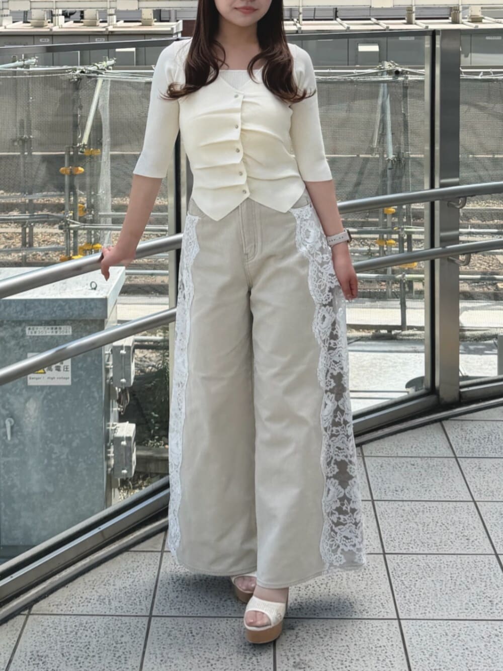 ホワイト系のニット/セーター、ベージュ系のデニムパンツ、ホワイト系のサンダルを着用したレディースの夏コーディネートの1枚目の写真
