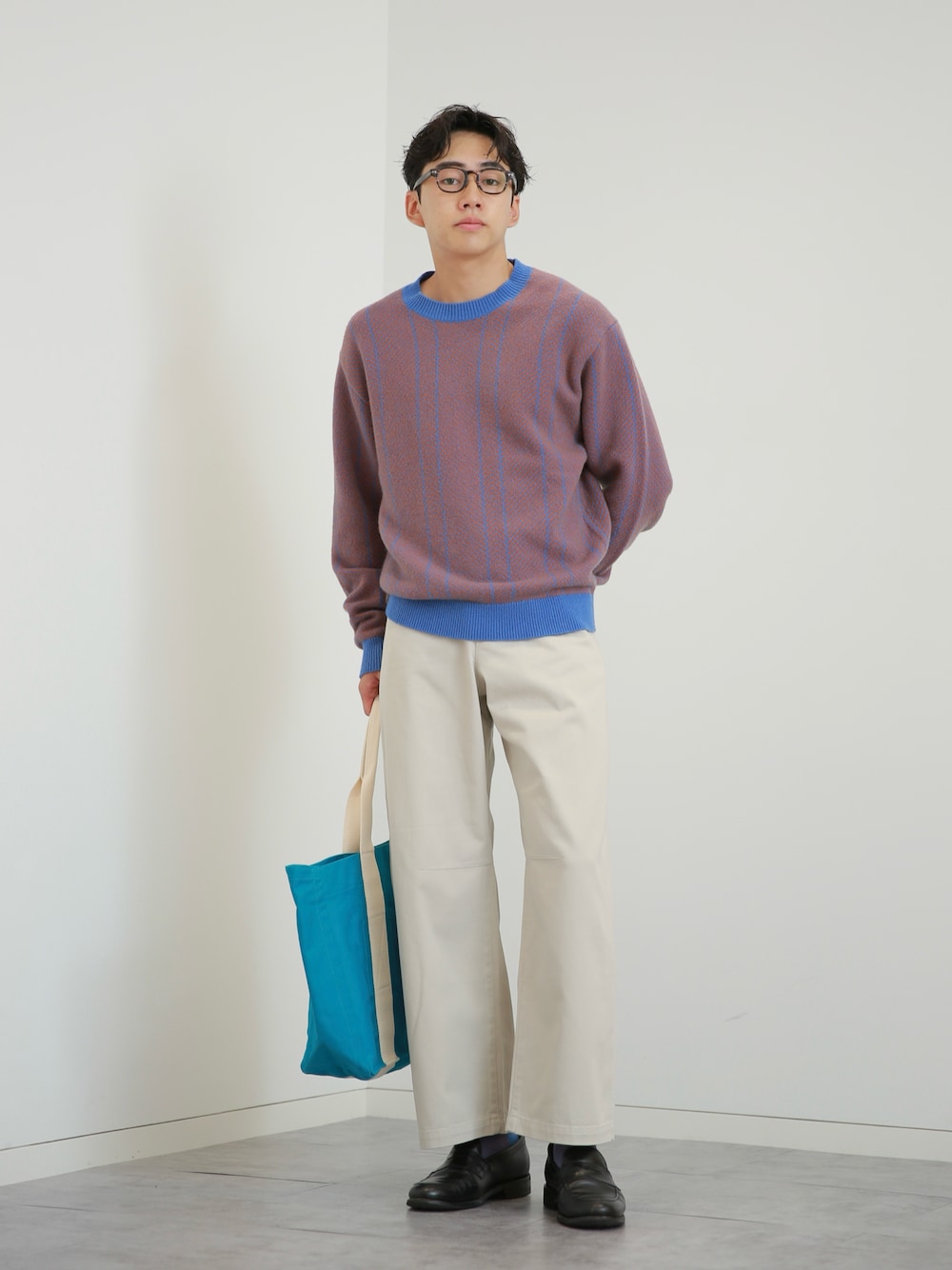ブルー系のニット/セーター、ホワイト系のチノパンツ、ブラック系のローファーを着用したメンズの秋コーディネートの1枚目の写真