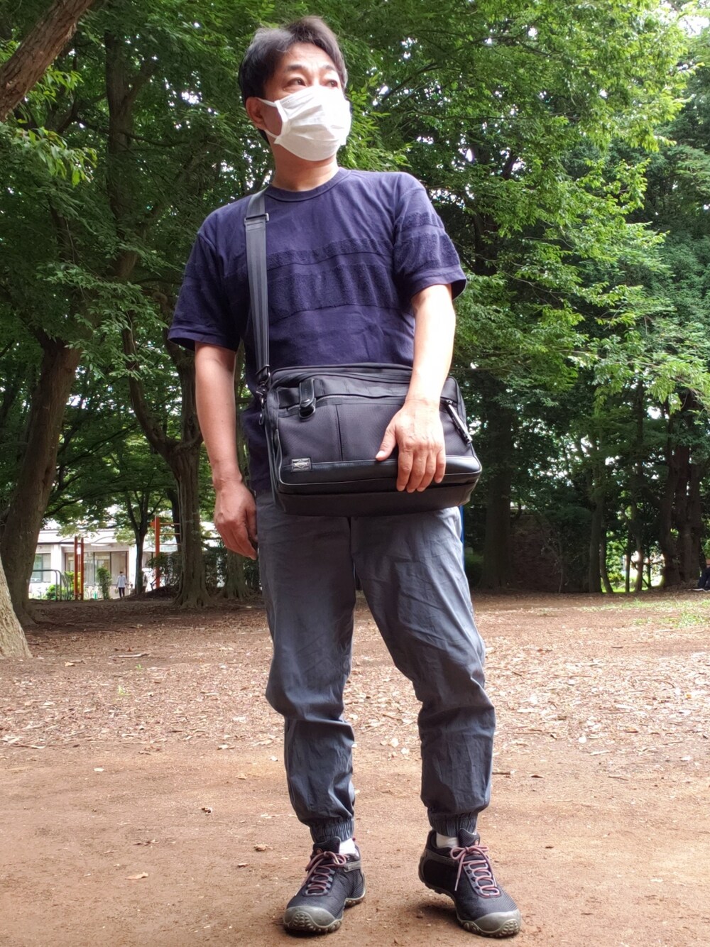 ブラック系のTシャツ/カットソー、ブラック系のショルダーバッグ、ブルー系のカーゴパンツを着用したメンズの夏コーディネートの1枚目の写真
