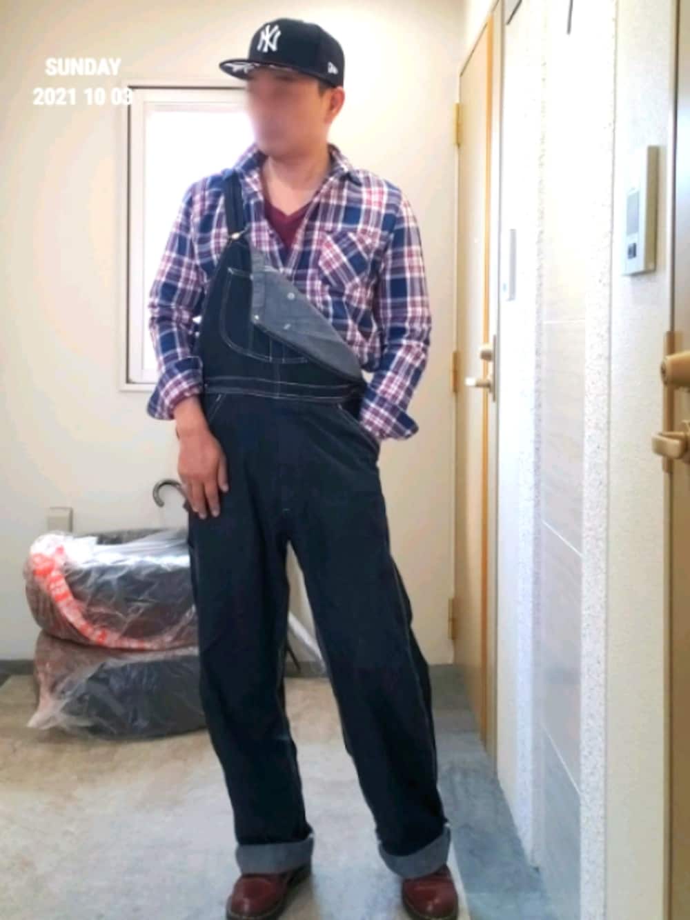 レッド系のシャツ/ブラウス、ブラック系のサロペット/オーバーオール、ブラウン系のブーツを着用したメンズの秋コーディネートの1枚目の写真