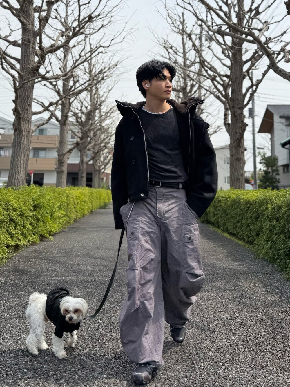 ブラック系のその他アウター、ブラウン系のパンツを着用したメンズの春コーディネートの1枚目の写真