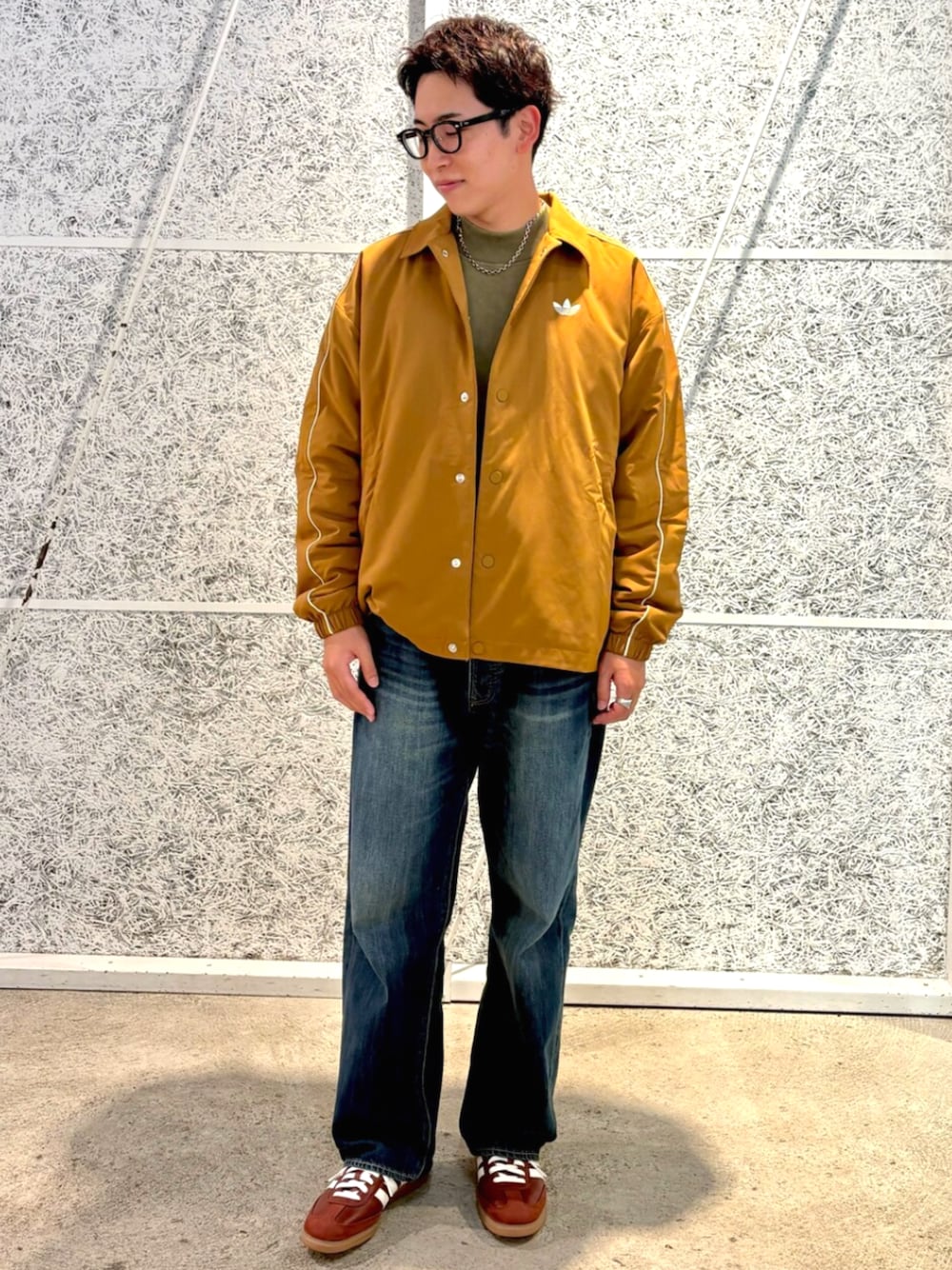 ブラウン系のブルゾン、グリーン系のトップス、ブラウン系のスニーカーを着用したメンズの秋コーディネートの1枚目の写真