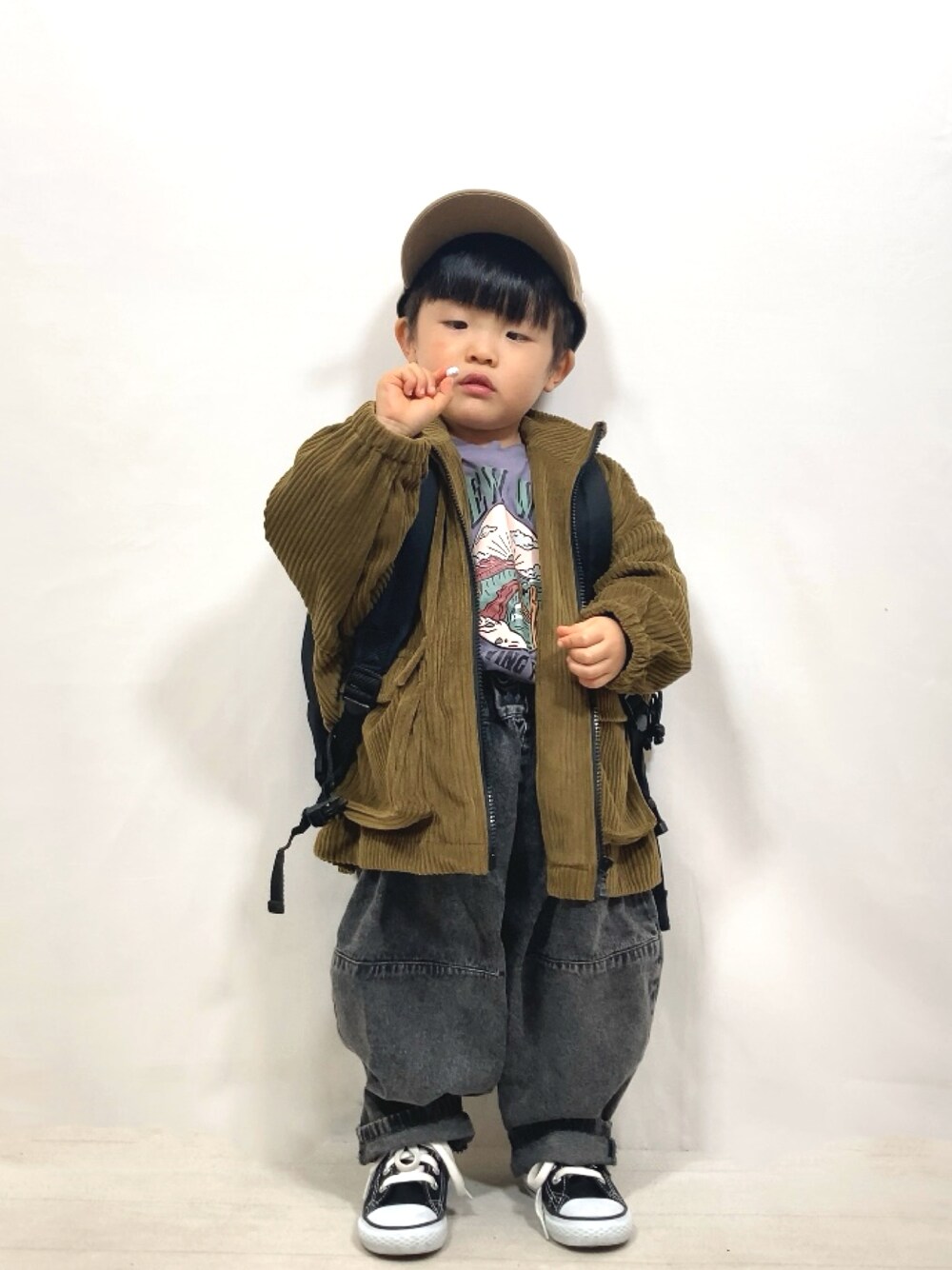 グリーン系のブルゾン、パープル系のTシャツ/カットソー、ブラック系のデニムパンツを着用したキッズの冬コーディネートの1枚目の写真