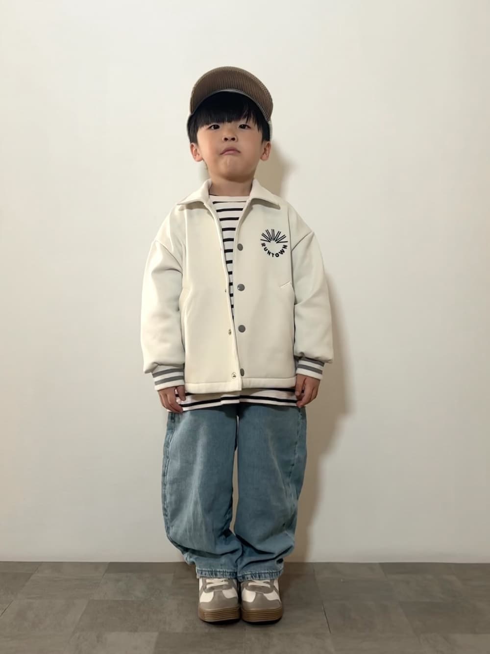 グリーン系のTシャツ/カットソー、ホワイト系のジャケット/アウター、ブルー系のデニムパンツを着用したキッズの冬コーディネートの1枚目の写真