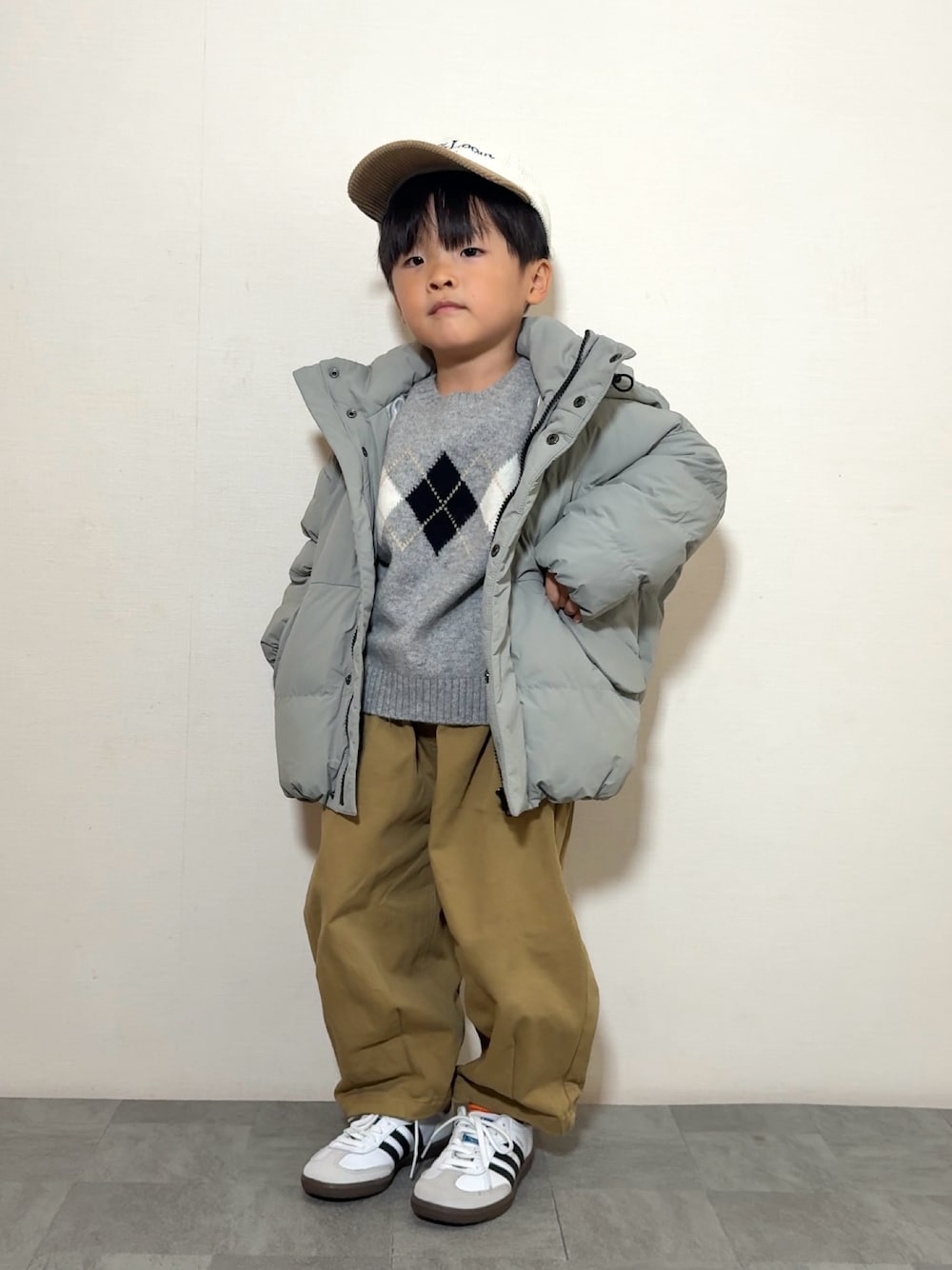 ブラウン系のその他パンツ、ホワイト系のスニーカー、グリーン系のブルゾンを着用したキッズの秋コーディネートの1枚目の写真