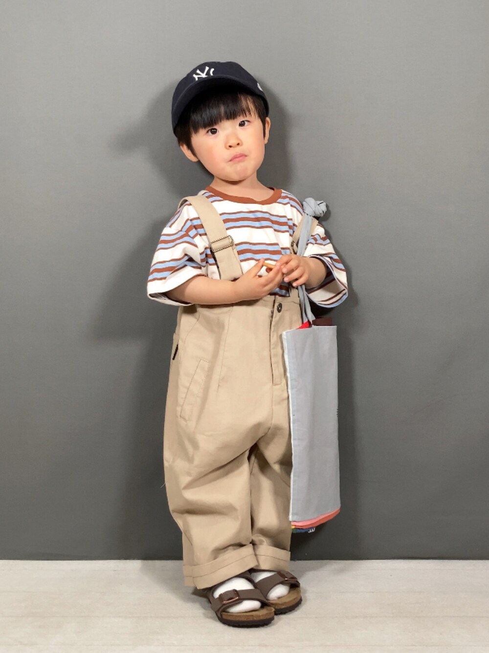 「韓国子供服、サロペット、淡色コーデ、トートバッグ、キャップ、サンダル、お出かけコーデ、休日スタイル、春コーデ、カジュアルコーデ、スポーツミックス、レイヤードスタイル、ボーダー」｜「韓国子供服のアイテム（Tシャツ/カットソー、ベージュ系）」を使った、YU⭐︎さん（キッズ・90cm）の春コーディネートの1枚目の写真