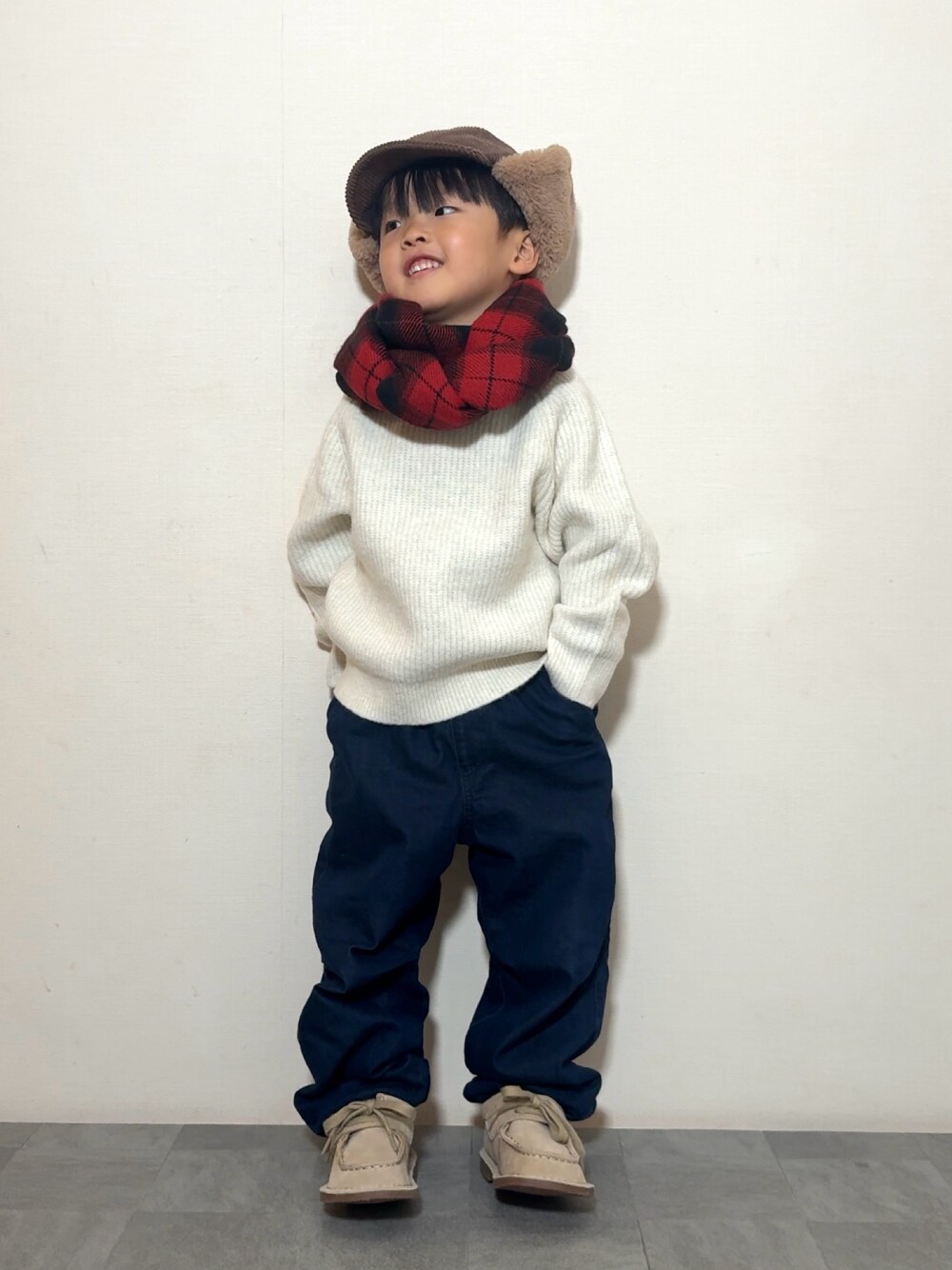 ベージュ系のモカシン/デッキシューズ、ホワイト系のニット/セーター、ブルー系のデニムパンツを着用したキッズの冬コーディネートの1枚目の写真