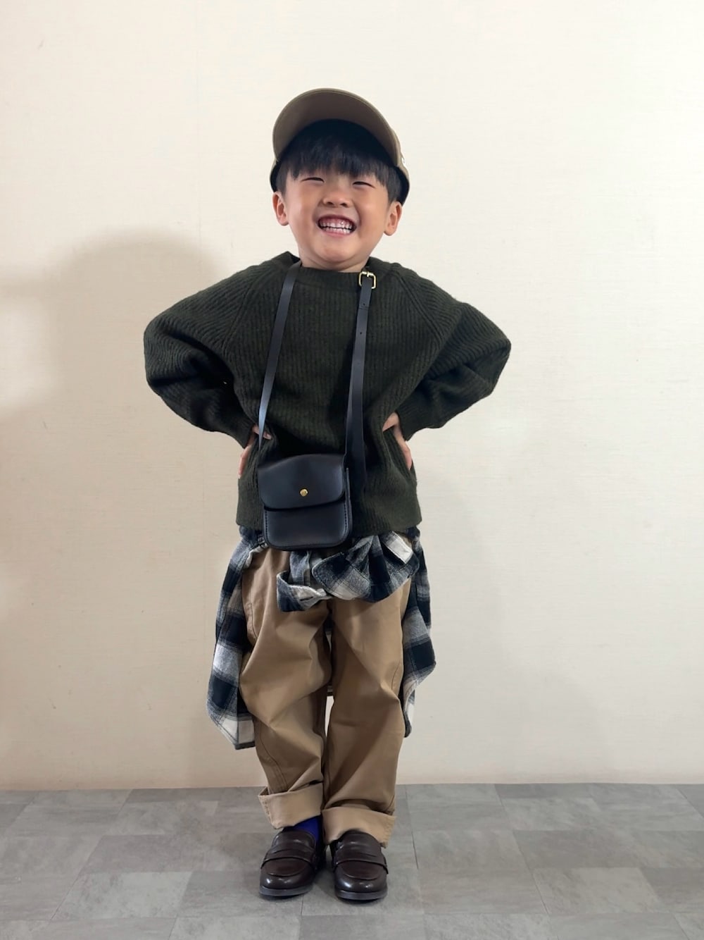 ブラウン系のローファー、グリーン系のニット/セーター、ブラック系のシャツ/ブラウスを着用したキッズの秋コーディネートの1枚目の写真