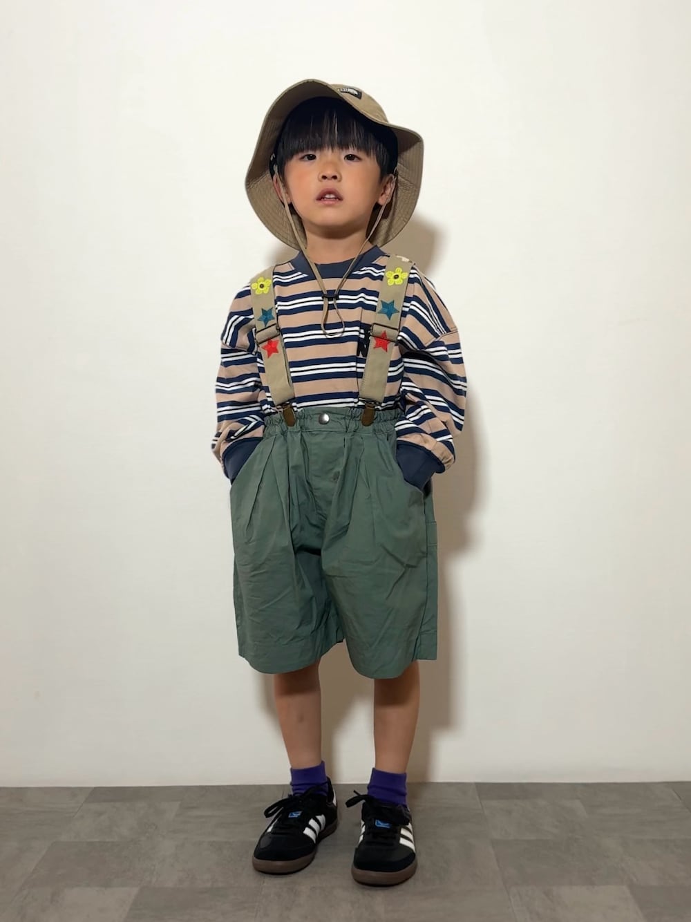 ブルー系のTシャツ/カットソー、ブラック系のスニーカー、グリーン系のその他パンツを着用したキッズの春コーディネートの1枚目の写真