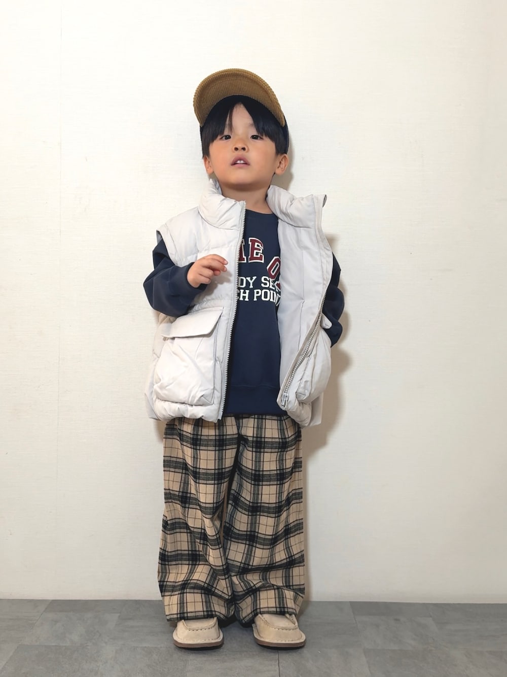 ベージュ系のモカシン/デッキシューズ、ブルー系のスウェット、ホワイト系のジャケット/アウターを着用したキッズの冬コーディネートの1枚目の写真