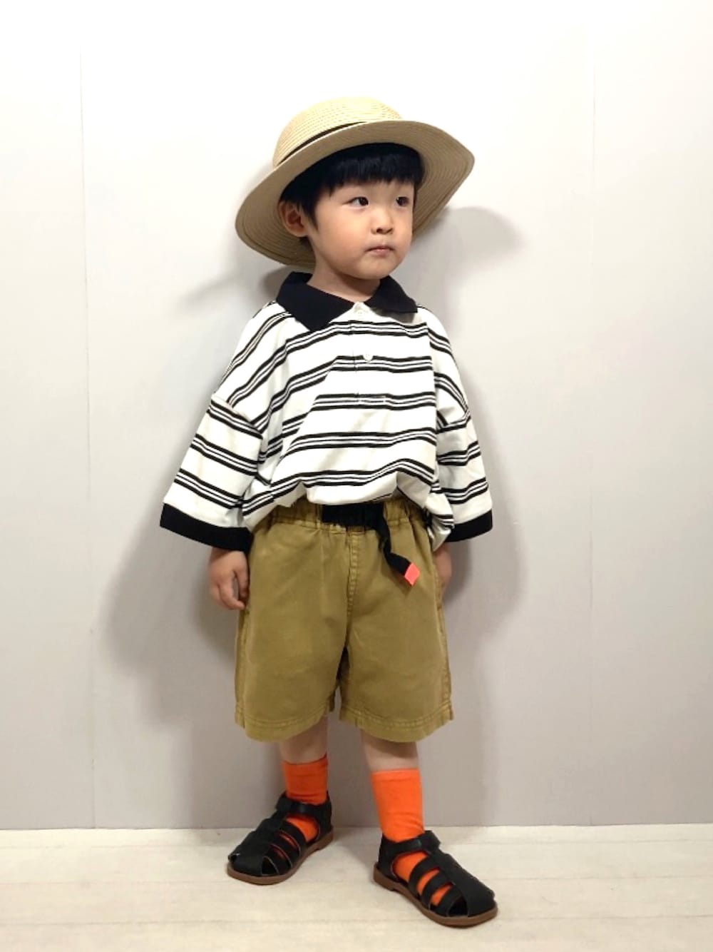 ベージュ系のポロシャツ、イエロー系のその他パンツ、ブラック系のサンダルを着用したキッズの夏コーディネートの1枚目の写真