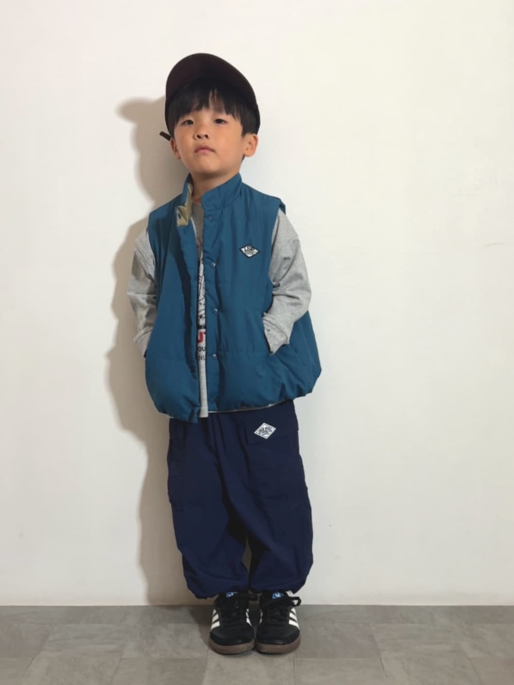 ブラック系のスニーカー、グレー系のTシャツ/カットソー、ブルー系のカーゴパンツを着用したキッズの秋コーディネートの1枚目の写真