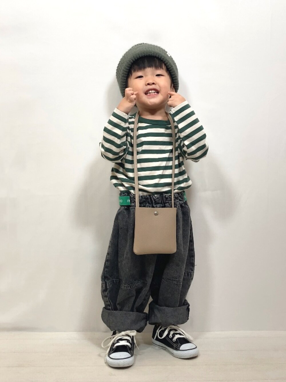 グリーン系のTシャツ/カットソー、ブラック系のデニムパンツ、ベージュ系のショルダーバッグを着用したキッズの夏コーディネートの1枚目の写真