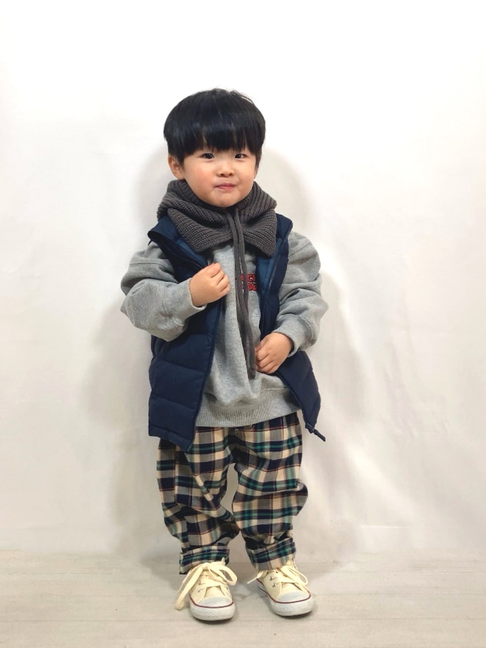 グレー系のスウェット、ブルー系のダウンベスト、ブルー系のその他パンツを着用したキッズの秋コーディネートの1枚目の写真