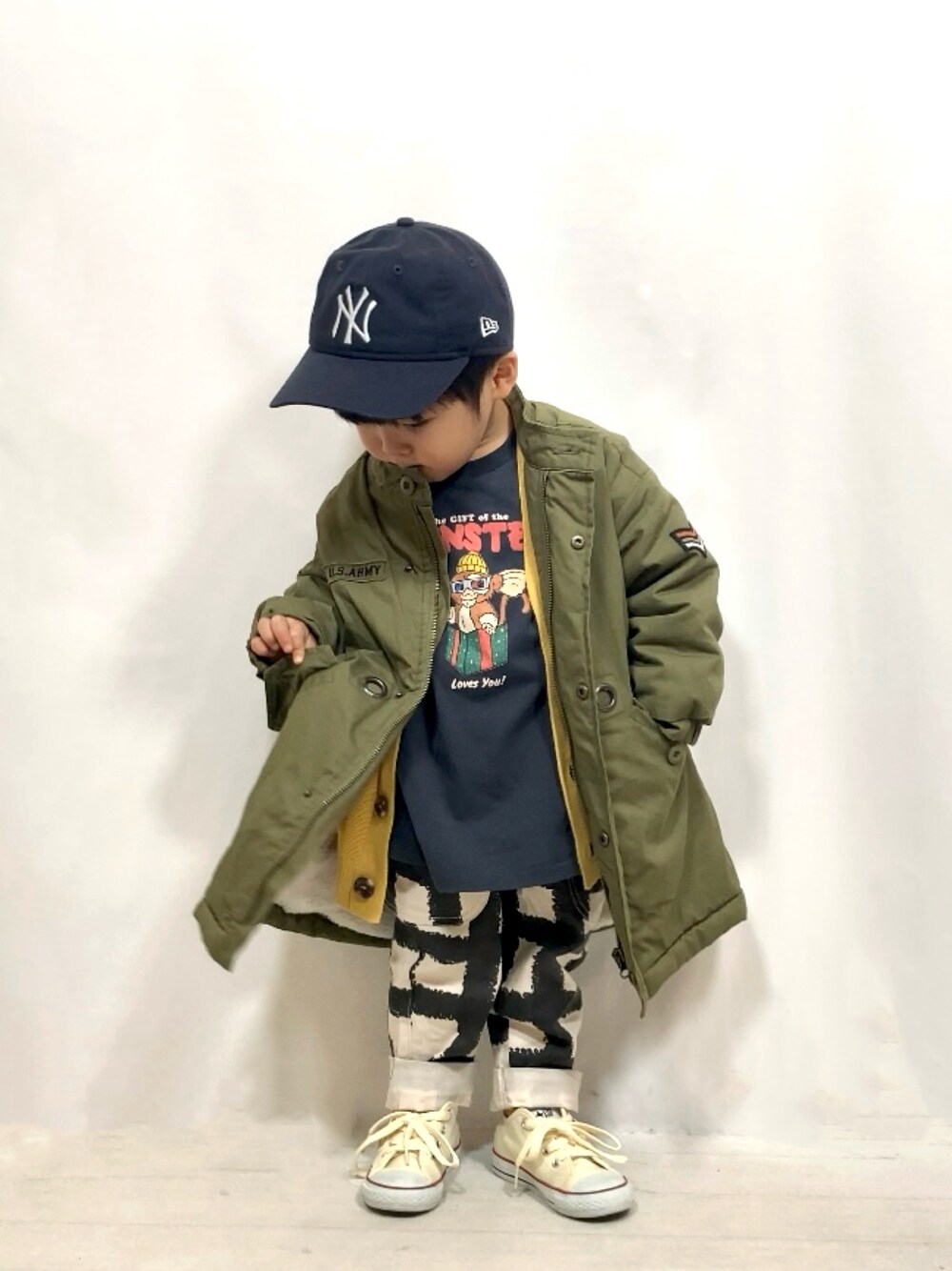 グリーン系のジャケット/アウター、イエロー系のカーディガン/ボレロ、グレー系のトップスを着用したキッズの冬コーディネートの1枚目の写真
