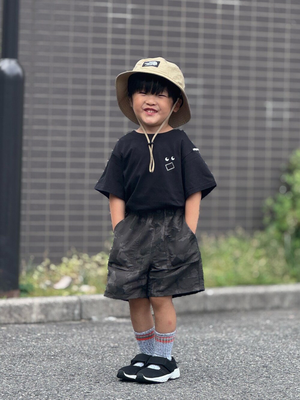 ブラック系のTシャツ/カットソー、グレー系のパンツ、ブラック系のサンダルを着用したキッズの夏コーディネートの1枚目の写真